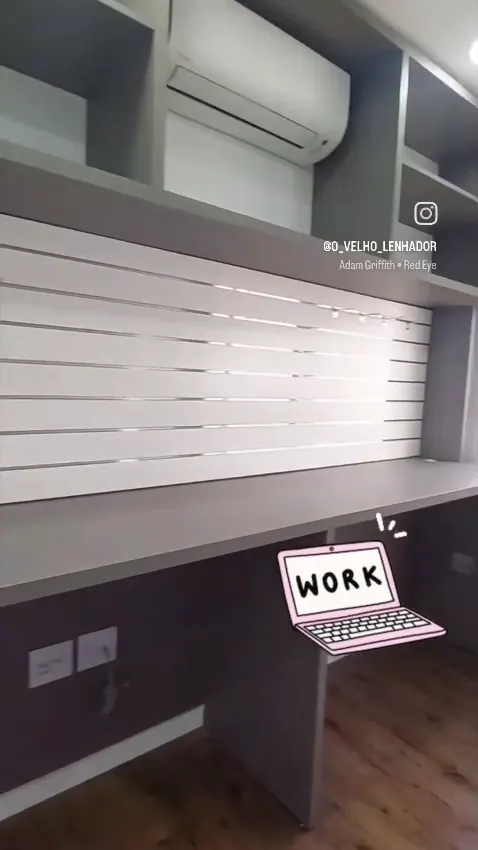 Sala com bancada corrida, prateleiras e painel ripado na parede