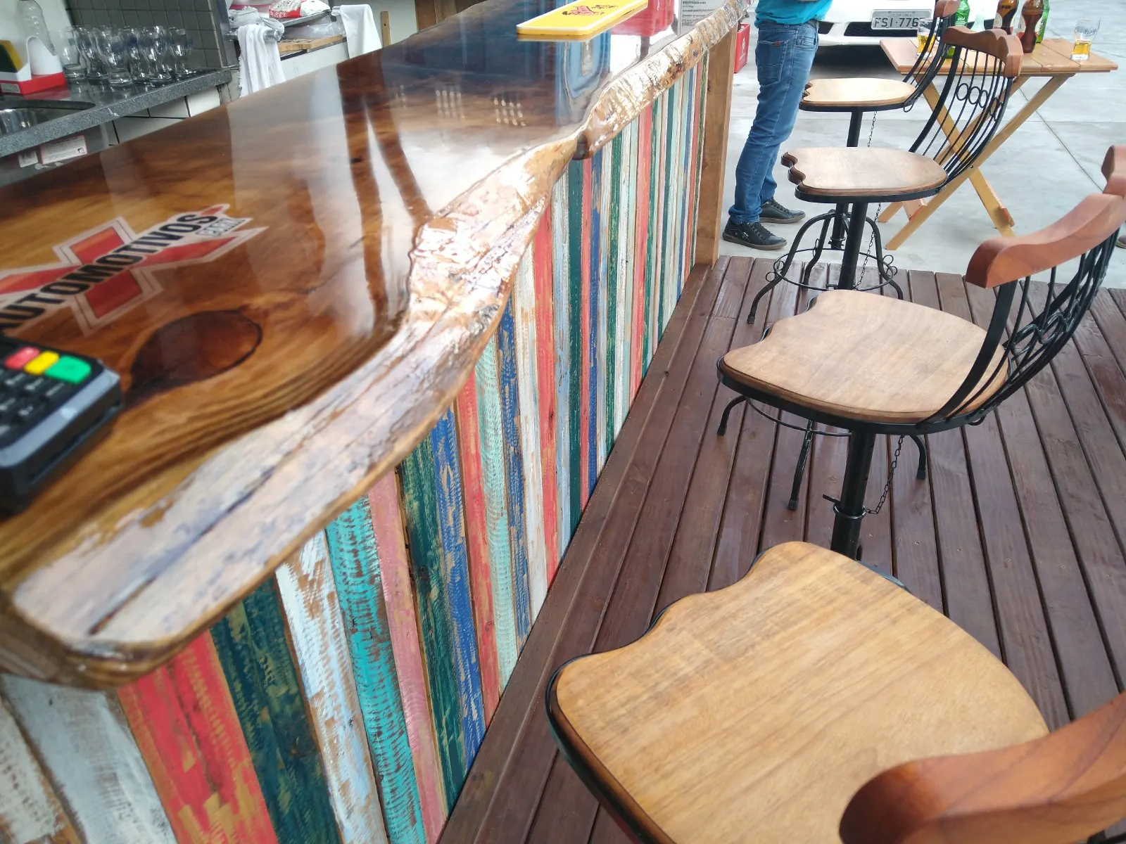 Banquetas de madeira junto ao balcão do bar externo