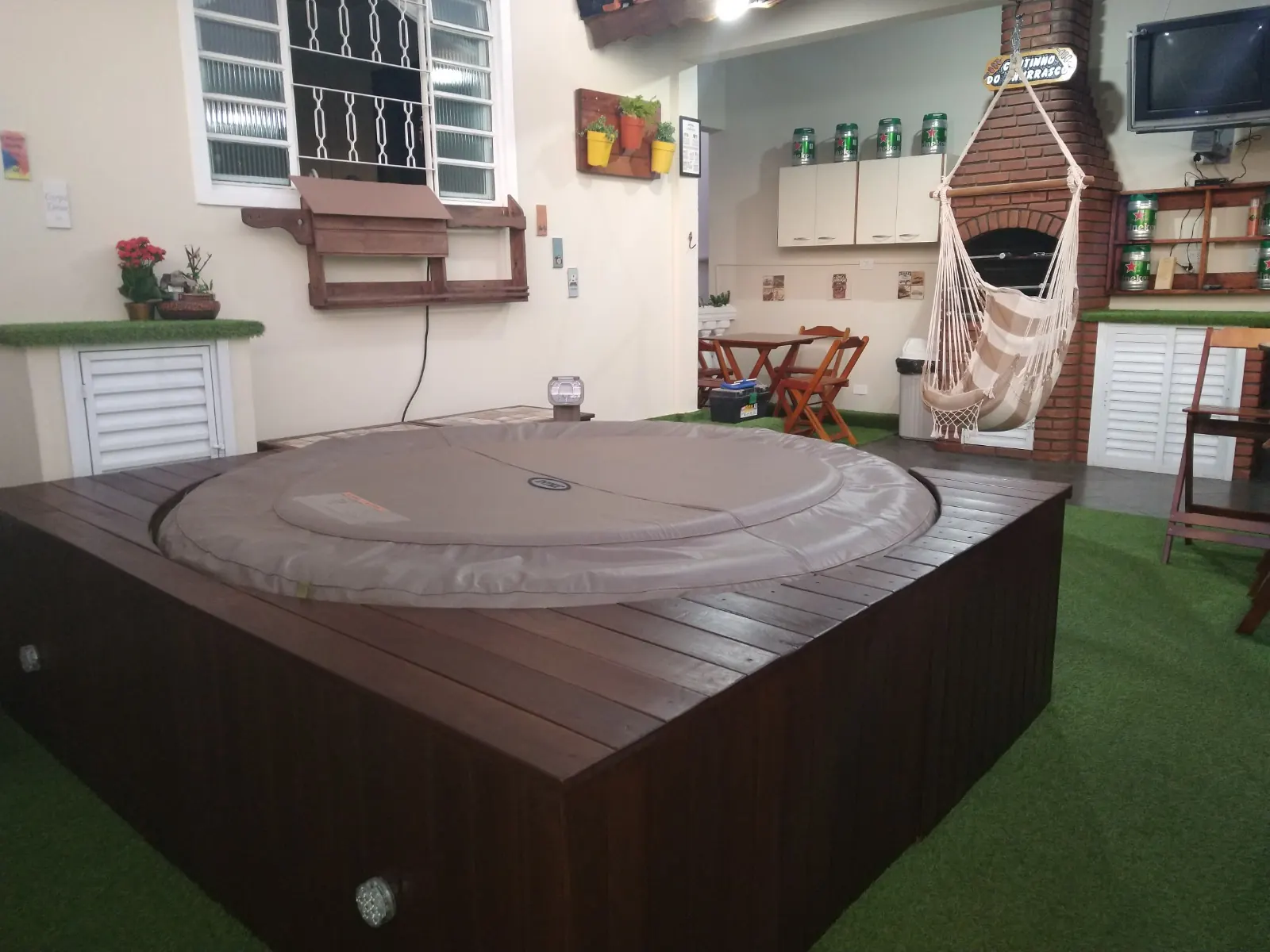 Ofurô redondo com deck de madeira sobre grama sintética